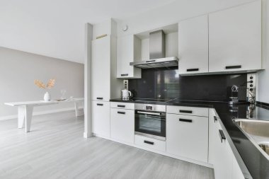 Yeni lüks bir evde mutfak, ahşap döşemeler, karanlık dolaplar.