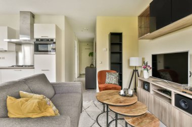 Konforlu bir oturma odası, şık mobilyalar, ve bitişik mutfak alanı, modern tasarım unsurları ve konfor içeren modern bir oturma odası..