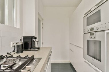 Modern aletlerin, temiz çizgilerin ve çağdaş bir tasarımın yer aldığı gösterişli ve minimalist bir mutfak. Aşçılık meraklıları ve ev dekorasyonu için ideal..