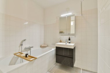 Beyaz fayanslı bir duvar, zarif eşyalar ve sakin bir atmosfer için minimalist dekorun yer aldığı gösterişli ve çağdaş bir banyo..