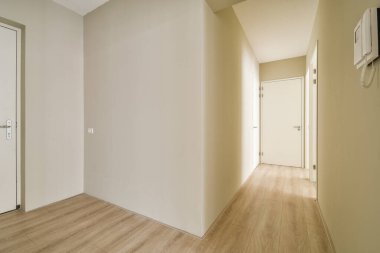 Temiz, minimalist bir koridorda nötr tonlar ve basit çizgiler yer ve ışık vurguluyor. Modern iç estetik için ideal..