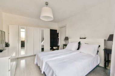 Konforlu bir yatak odası tasarımı, minimalist mobilyalar ve iyi düzenlenmiş bir gardırop, çağdaş yaşam için mükemmel..