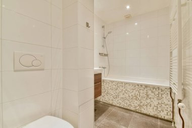 Zarif ve çağdaş banyo. Tarafsız fayanslar, küvet ve zarif dokunuşlar için şık eşyalar..