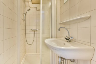 Zarif ve minimalist bir banyo tasarlandı. Geniş bir duş bölmesi ve şık bir lavabo. Fayanslar çağdaş estetiği güçlendiriyor..