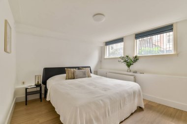 Sakin ve basit bir yatak odası. Rahat bir yatak odası, şık bir dekor ve pencerelerden süzülen doğal bir ışık..