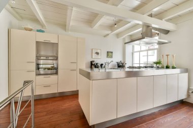 Minimalist tasarım unsurları, geniş bir depo ve yemek pişirmek ve eğlendirmek için ideal fonksiyonel bir tasarım içeren şık, modern bir mutfak..