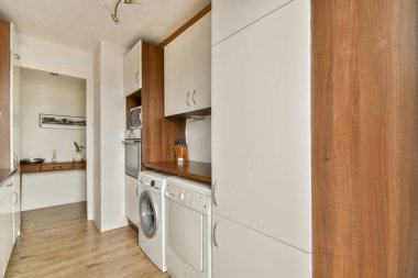 Zarif bir mutfak manzarası, verimlilik ve tarz için tasarlanmış gösterişli dolaplar ve aletler. Yerleşim alanı ve işlevselliği maksimuma çıkarır.