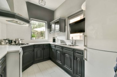 Gri dolapları, beyaz tezgahları ve şık ışıklandırmaları olan şık ve modern bir minimalist mutfak, çağdaş bir yemek alanı yaratıyor..