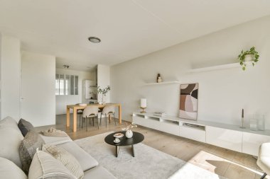 Tarafsız tonlara, şık mobilyalara ve modern ortamlarda rahatlığı ve rahatlığı teşvik eden rahat bir atmosfere sahip minimalist modern oturma odası..