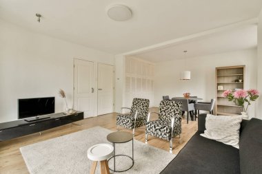 Zarif mobilyaların, rahat bir ambiyansın ve onu davetkar ve şık yapan işlevsellik ve estetiğin karışımından oluşan modern bir oturma odası..