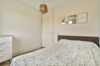 Beyaz bir yatak örtüsü, minimalist bir dekor ve atmosferi güçlendiren doğal bir ışık içeren sakin ve şık bir yatak odası. Rahatlamak ve rahatlamak için ideal..