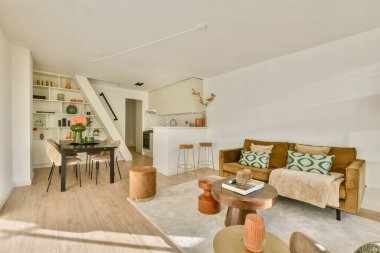 Rahat bir oturma alanı, yemek masası ve sıcak dekor unsurları olan şık, modern bir yaşam alanı. Modern yaşam için konfor ve estetiği mükemmel bir şekilde dengelemek..