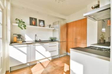 Parlak, çağdaş mutfak, gösterişli dolap şiirleri, ahşap aksanlar, ve doğal ışık açık tasarımı geliştiriyor, hoş bir atmosfer yaratıyor..