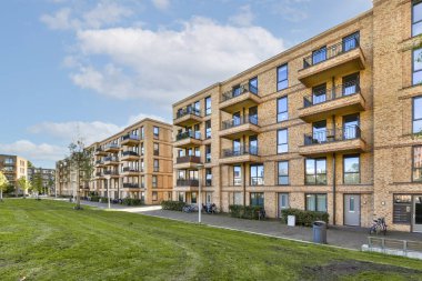 Çağdaş bir konut kompleksi. Balkonlu ve manzaralı yeşil alanları olan birden fazla apartman dairesi var..