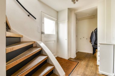 Çağdaş bir merdiven, ahşap döşeme ve minimalist bir dekor sergiliyor. Zarafet ve açıklık hissi yaratıyor..