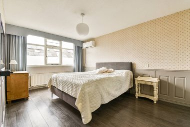 Bu modern yatak odası açık renk paleti, rahat bir yatak odası, ahşap döşeme ve şık perdeler içeriyor, sakin ve davetkar bir atmosfer yaratıyor..