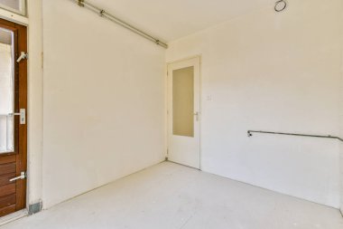 Sade bir duvar ve açık bir kapı içeren basit, temiz bir iç mekan. Estetik, nötr tonlarla minimalizmi yansıtır..