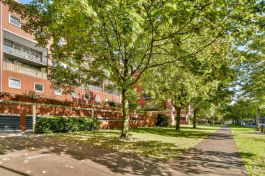 Canlı bir park manzarası, yemyeşil ağaçlar ve modern konut binalarının yanında iyi korunmuş yollar sergiliyor. Toplum rahatlığı ve açık hava aktiviteleri için mükemmel..