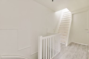 Üst ve alt katlara giriş yapan bir koridorda merdivenler.