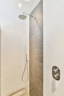 Parlak bir banyoda modern duş kabini.