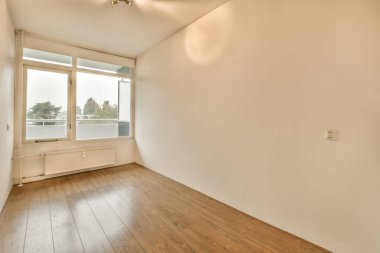 Mobilyasız, geniş bir odanın içinde.