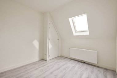 Küçük penceresi ve ısıtma sistemi olan boş bir oda.