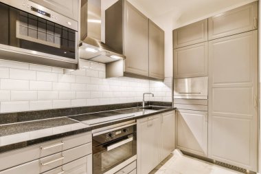 Yeni lüks bir evde mutfak, ahşap döşemeler, karanlık dolaplar.