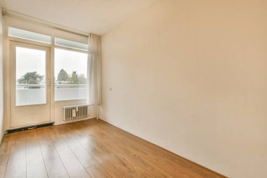 Mobilyasız, geniş bir odanın içinde.