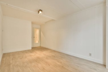 Mobilyasız, geniş bir odanın içinde.