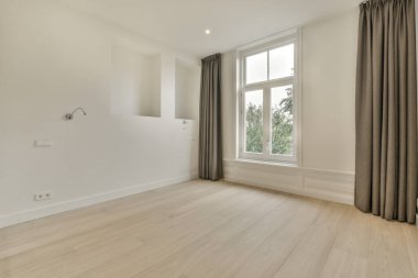 Mobilyasız, geniş bir odanın içinde.