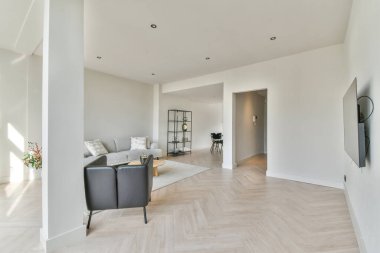 Modern oturma odasının içinde şık siyah mobilyalar var.