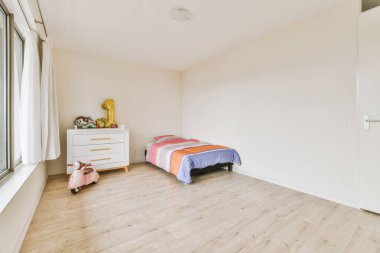 Yatak odasının iç tasarımı, yatak odası ve ahşap gardırop modern dairenin penceresinin kenarına yerleştirilmiş.