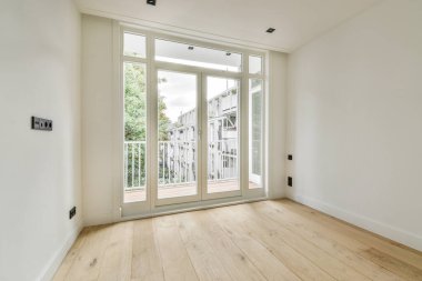 Mobilyasız, geniş bir odanın içinde.