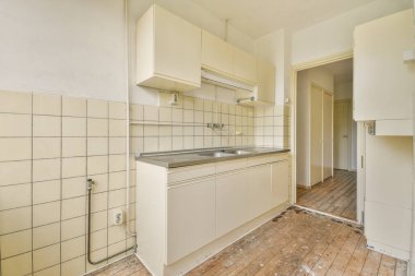 Beyaz fayanslı duvarları olan eski tarz bir mutfak odası.