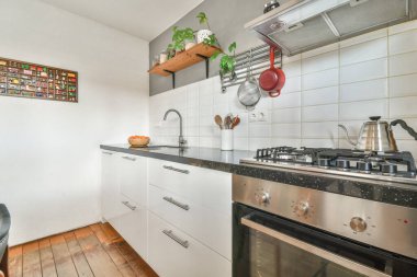 Yeni lüks bir evde mutfak, ahşap döşemeler, karanlık dolaplar.