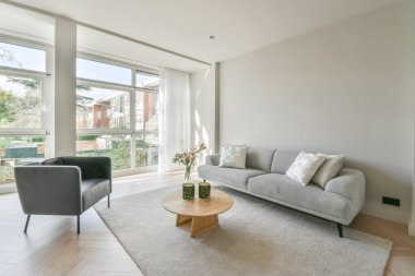 Modern oturma odasının içi pencerelerle dolu.