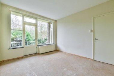 Balkona açılan kapısı olan boş bir oda.