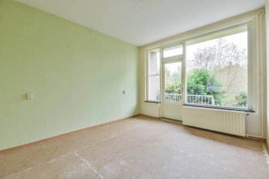 Balkona açılan kapısı olan boş bir oda.