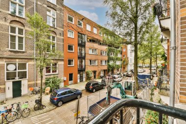 Amsterdam, Hollanda 'da park etmiş arabaları ve bisikletleri olan bir şehir caddesi - stockfoorenlimm com