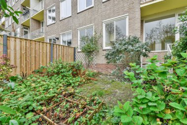 Çiçekleri ve ağaçları olan bir apartmanın yeşil bahçesi