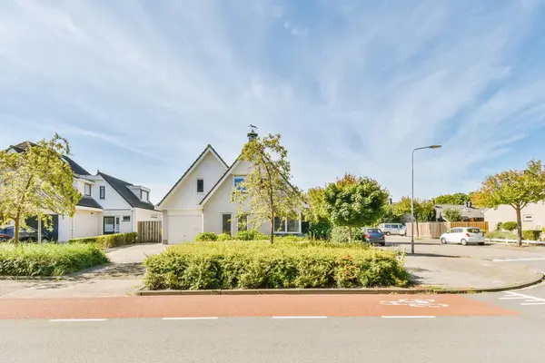 Arka planda evleri olan boş bir cadde ve yolun karşısından görünen gökyüzü üzerinde mavi gökyüzü.