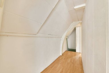 Minimalist tasarım elementleri, yumuşak ışıklandırma ve davetkar bir atmosfer yaratan temiz çizgiler içeren geniş, modern bir koridor..