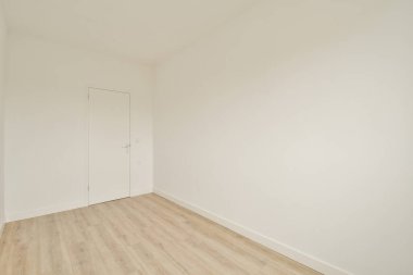 Geniş, minimalist bir oda, düz beyaz duvarlar, ahşap bir zemin ve tek bir kapı. Modern tasarım estetiği ve iç dekorasyon için ideal..