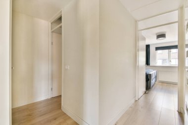 Tarafsız renkler ve modern tasarım unsurlarının yer aldığı temiz ve basit bir koridor. Mekan aydınlık ve davetkar, minimalist bir estetiği yansıtıyor..