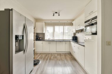 Zarif ve çağdaş bir mutfak, paslanmaz çelik aletler, minimalist dolaplar ve camdan içeri akan doğal ışık, davetkar bir atmosfer yaratıyor..