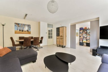 Modern oturma odasının modern mobilyaları, şık dekorları ve rahatlama ve eğlence için ideal rahat bir atmosferi var..