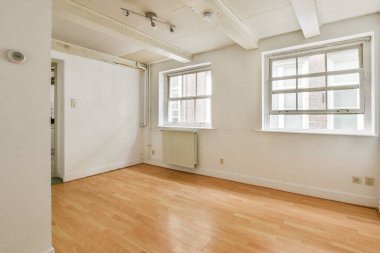 Minimalist tasarımı, soluk ahşap döşemeleri ve doğal ışığı davet eden büyük pencereleri olan havadar ve geniş bir iç mekan..