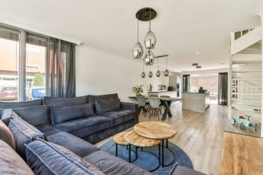 Rahat bir kanepe, zarif mobilyalar ve parlak, açık bir atmosferi olan modern bir oturma odası. Rahatlama ve sosyal toplantılar için ideal..