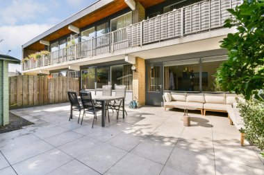 Bu resim modern mobilyalar, yeşillik ve rahatlama ve toplanma için mükemmel korunmuş bir atmosfer sunan şık bir veranda alanına sahiptir..