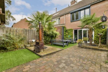 Bereketli bir yeşillik, rahat bir oturma alanı ve açık hava dekorları içeren sakin bir bahçe sahnesi, rahatlama ve açık hava keyfi için mükemmel..